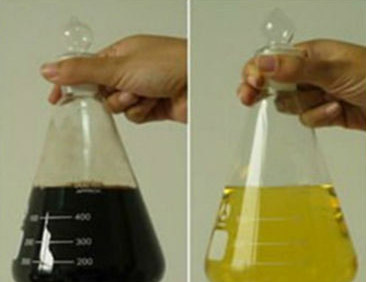 Two conical flasks held side by side: black used oil on the left, straw-coloured re-refined oil on the right